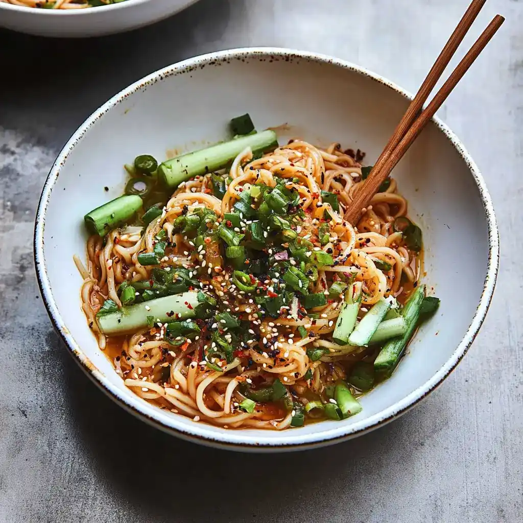 Low FODMAP chili oil noodles in white bowl with chopsticks